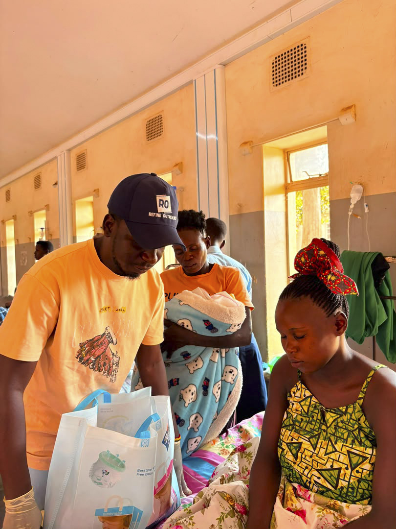 Refine Outreaches volunteer giving supplies to a mother at Jinja hospital